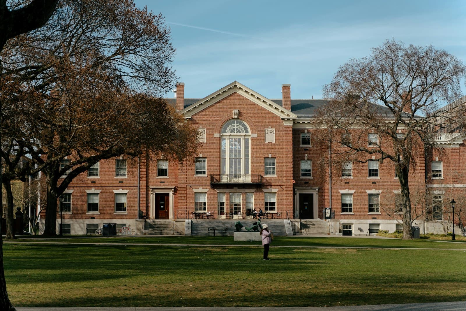 A red brick school building with a lawn and trees